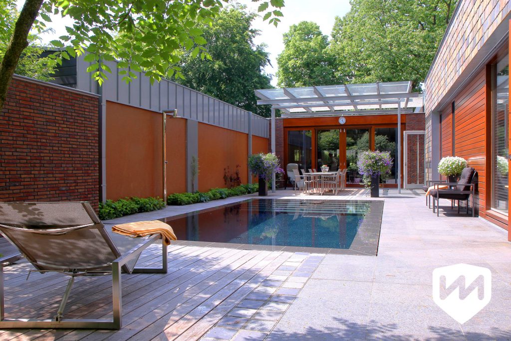 Moderne bostuin met luxe infinity overloop zwembad. Tuinarchitect door Van Mierlo Tuinen.